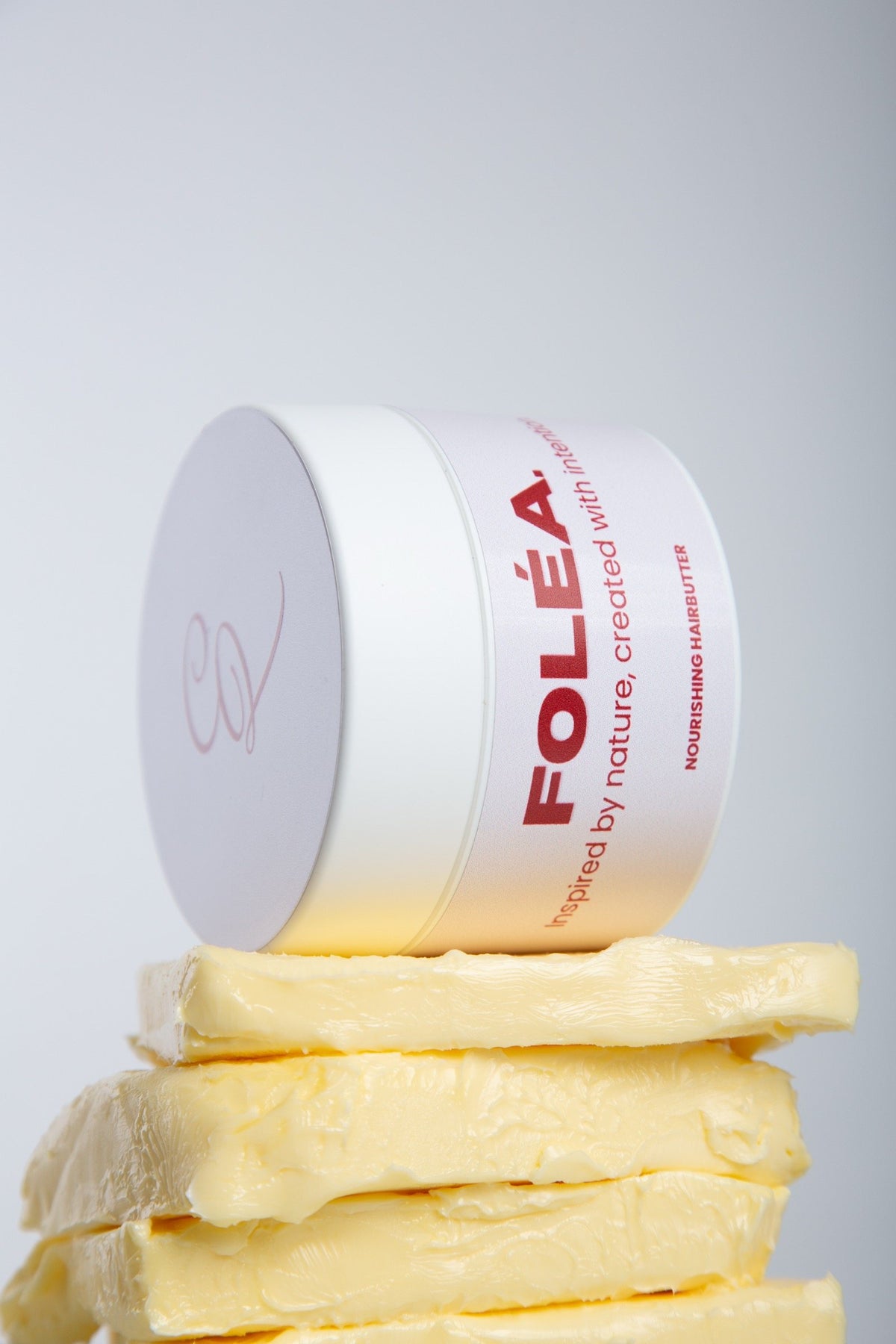 Pot FOLÉA Nourishing hairbutter op een stapel verse boter